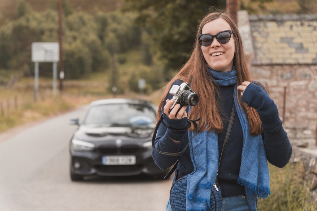 Anna McCourt, wedding photographer, holding her camera smiling