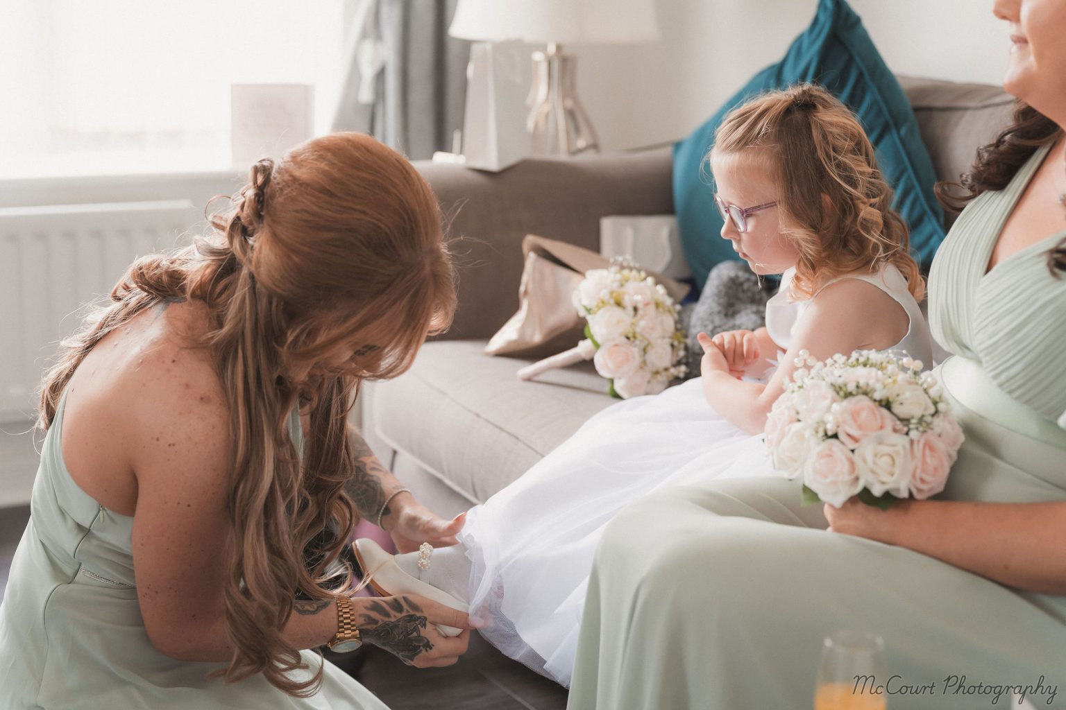 Brides maid helping the flower girls get ready before the wedding