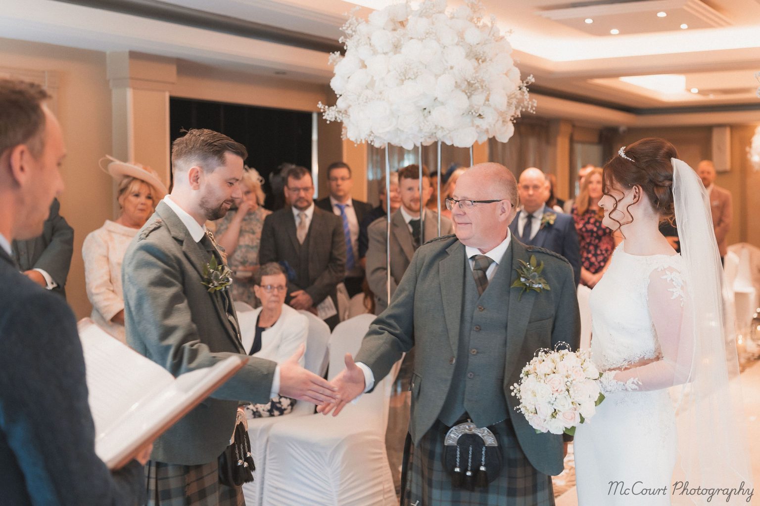 Father of the bride shaking hands with the brides new husband before they get married at the dalziel park hotel