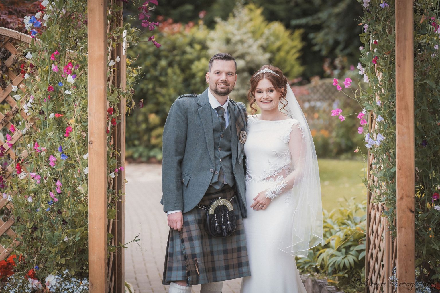 Picture of the newly married couple at the dalziel park hotel under the arch in the garden